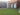 Brick building with a stone wall and green lawn - Residential Design Example